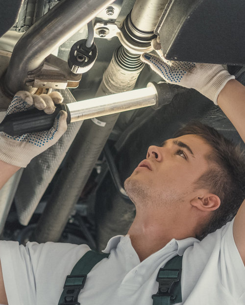 Mechanic looking under a vehicle - Car MOT Swindon